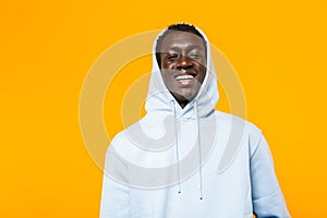 Image of african american guy in streetwear hoodie standing and smiling photo