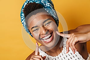 Image of african american woman pointing fingers at her cheeks