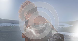 Image of african american woman relaxing at sunny beach over landscape