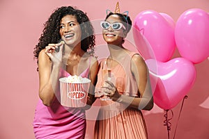 Image of african american women drinking champagne and eating popcorn