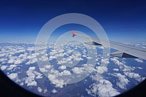 Image of airplane wing and beautiful clouds from the window of the plane. Beautiful with the blue sky