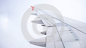 Image of airplane wing flying in bad weather conditions, fog and clouds