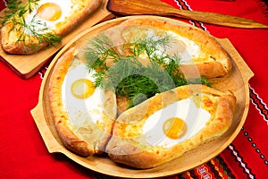 An image of an Ajarian khachapuri on table with raw egg close up