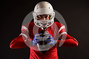 Image of american female football player in helmet with rugby ball in hands