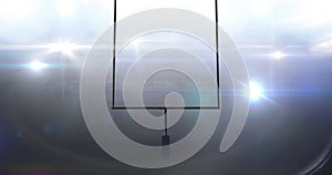 Image of american football goalposts and cloudy sky at floodlit stadium