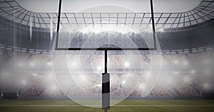 Image of american football goalposts and cloudy sky at floodlit stadium