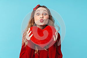 Image of amusing blonde woman holding toy heart and making kiss