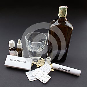 Image of anxiolytic pills, antidepressants, sleeping pills and bottle of alcohol. Addictions and abuse in the new millennium