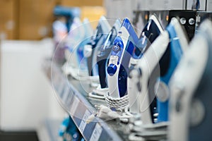Image of assortment of different irons at household appliances shop
