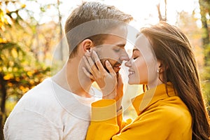 Image of attractive young caucasian couple hugging at autumn park