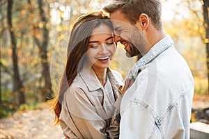 Image of attractive young caucasian couple walking through autumn park