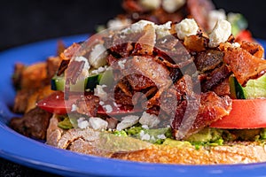 Image of avocado bacon toast with cucumber, tomato and cheese.