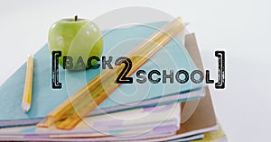 Image of back to school text over apple and school items