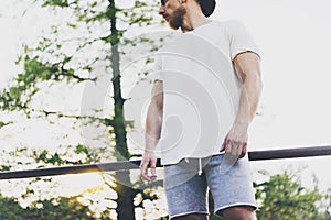 Image Bearded Muscular Man Wearing White Blank t-shirt, snapback cap and shorts in summer vacation.Relaxing time after