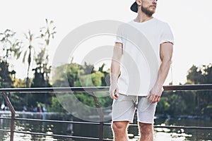 Image Bearded Muscular Man Wearing White Blank t-shirt, snapback cap and shorts in summer vacation. Relaxing time near