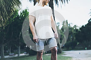 Image Bearded Muscular Man Wearing White Empty t-shirt and shorts in summer holiday. Chilling time. Green City Garden