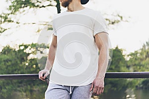 Image Bearded Muscular Man Wearing White Empty t-shirt, snapback cap and shorts in summer holiday. Chilling time near