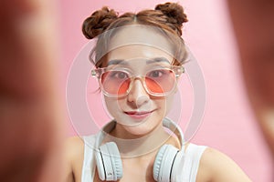 Image of a beautiful amazing happy excited young woman posing isolated over pink wall background take selfie by camera