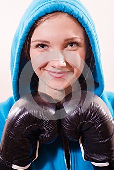 Image of beautiful girl in a blue hood and gloves for boxing, kick-boxing closeup portrait isolated on white background