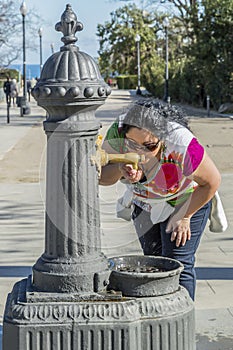 Image of a beautiful thirsty woman drinking water