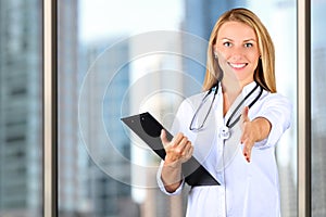 Image of beautiful woman doctor looking at camera and giving a hand