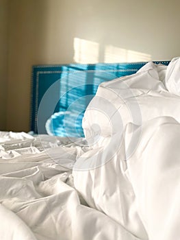 White Sheets Blue Head Board Bed in Room