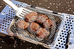 Burgers Being flipped on a Portable BBQ photo