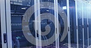 Image of binary coding numbers changing over tech room with computer servers