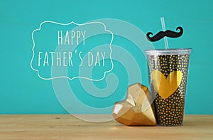 Image of black cup with golden heart. Father`s day concept.