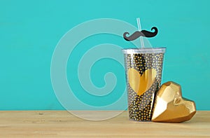 Image of black cup with golden heart. Father`s day concept.