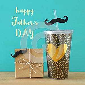 Image of black cup with golden heart. Father`s day concept.