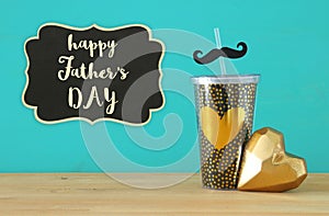 Image of black cup with golden heart. Father`s day concept.