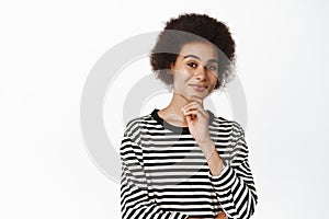 Image of black girl student, african woman thinking, smiling satisfied, having idea, pondering standing over white