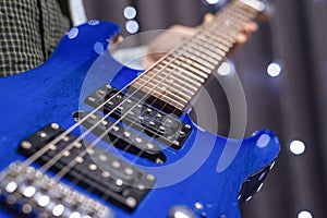 Image of a blue electric guitar close-up. The concept of tuning and repairing musical instruments