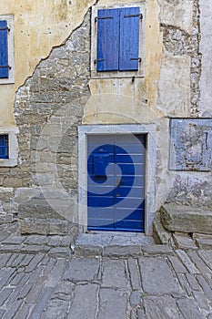 Image of a blue entrance door to a residential building with an antique faÃÂ§ade