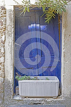 Image of a blue entrance door to a residential building with an antique faÃ§ade