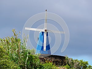 Image of blue wooden wind mill on a stone base