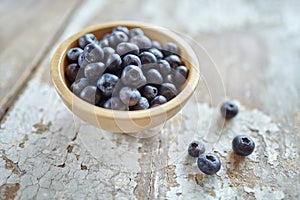 Image of blueberries in wooden bowl on rustic village table