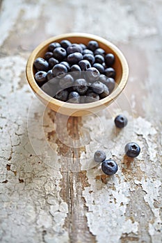 Image of blueberries in wooden bowl on rustic village table