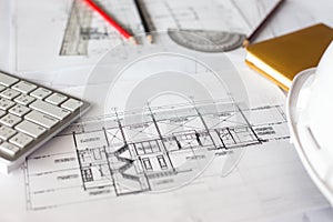 Image of blueprints with level pencil and hard hat on table