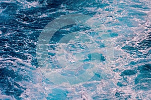 The image is of a body of water with blue waves and white foam