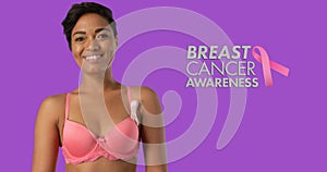 Image of breast cancer awareness text over smiling african american woman on purple background