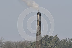 This is an image of bricks industries chimney and smokes .