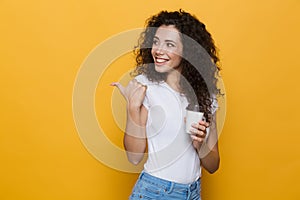 Image of brunette woman 20s with curly hair smiling and holding