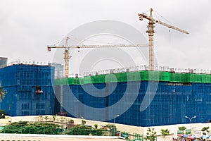 Image of a building in progress with security net around it. High building