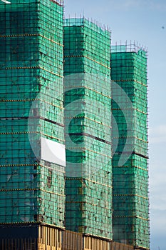 Image of a building in progress with security net around it. High building