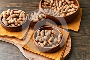 Image of bunch of peanuts in a bowl on a wooden table