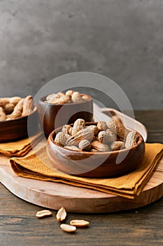 Image of bunch of peanuts in a bowl on a wooden table