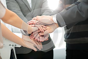 Image of business partners hands on top of each other symbolizin