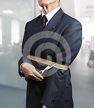 Image of businessman trying to get rid of fetters